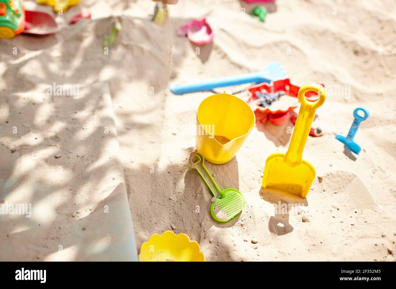 Sandbox all'aperto. Sandbox per bambini con vari giocattoli per il gioco. Concetto estivo. Messa a fuoco selettiva con profondità di campo ridotta Foto Stock