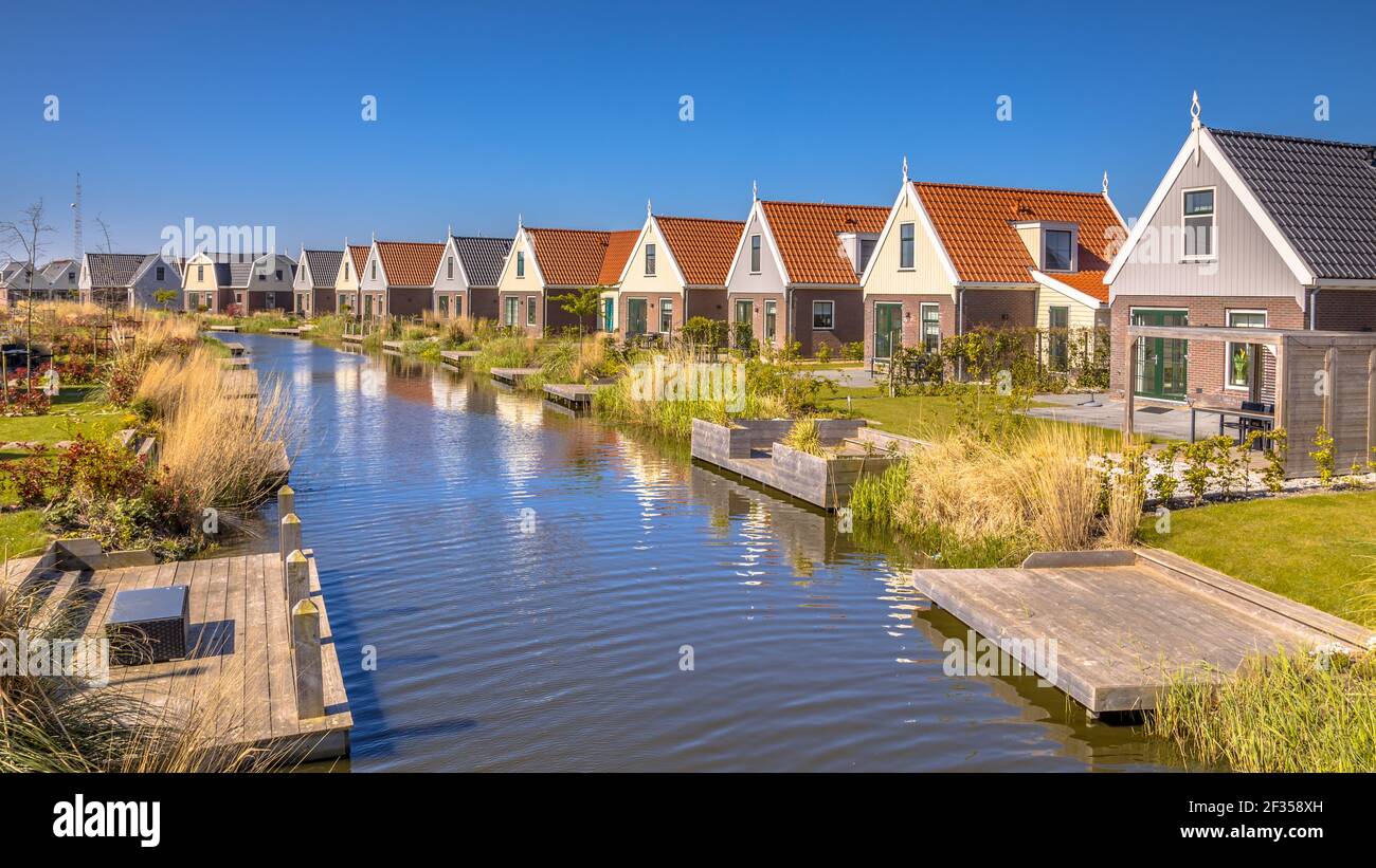 La scena fluviale del Resort Poort van Amsterdam è caratterizzata dalla sua posizione unica. Con chalet di stile tradizionale e l'acqua delicatamente scorrevole della Foto Stock