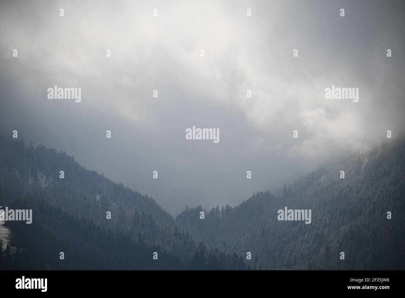 Paesaggi nebbosi e innevati di montagne Foto Stock