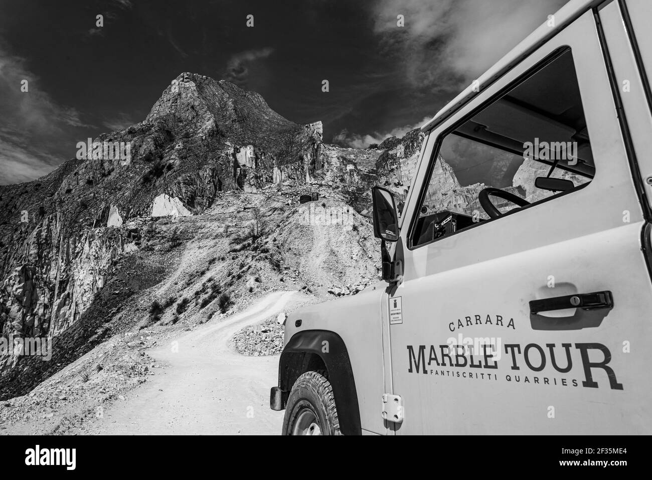 Immagine in bianco e nero di parte di veicolo fuoristrada con pubblicità sulle porte in cava di marmo di Carrara. Foto Stock