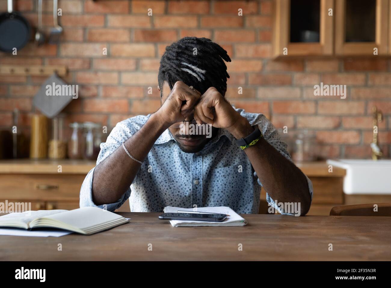 Stressato uomo nero Sit da copybooks smartphone sovraccarico di informazioni Foto Stock