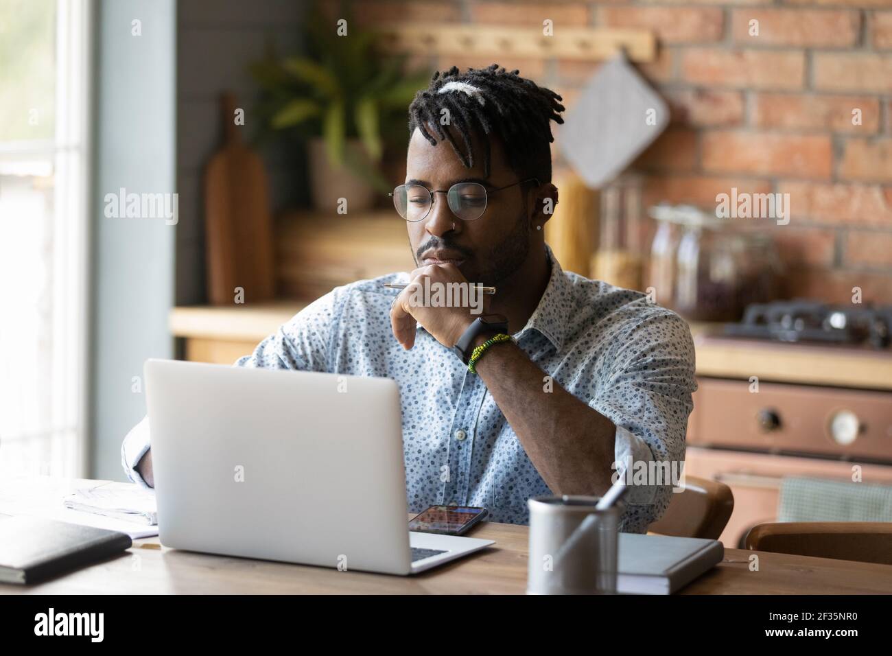 Risultato di ricerca Web di lettura maschile nero focalizzato sullo schermo del laptop Foto Stock