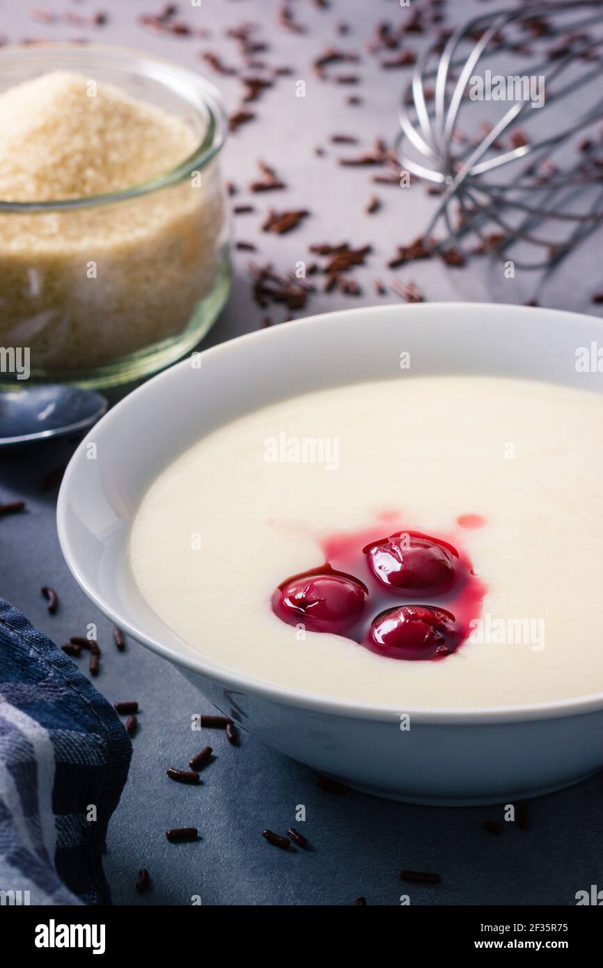 Porridge di semola con ciliegie e cioccolato e zucchero di canna nella parte posteriore Foto Stock