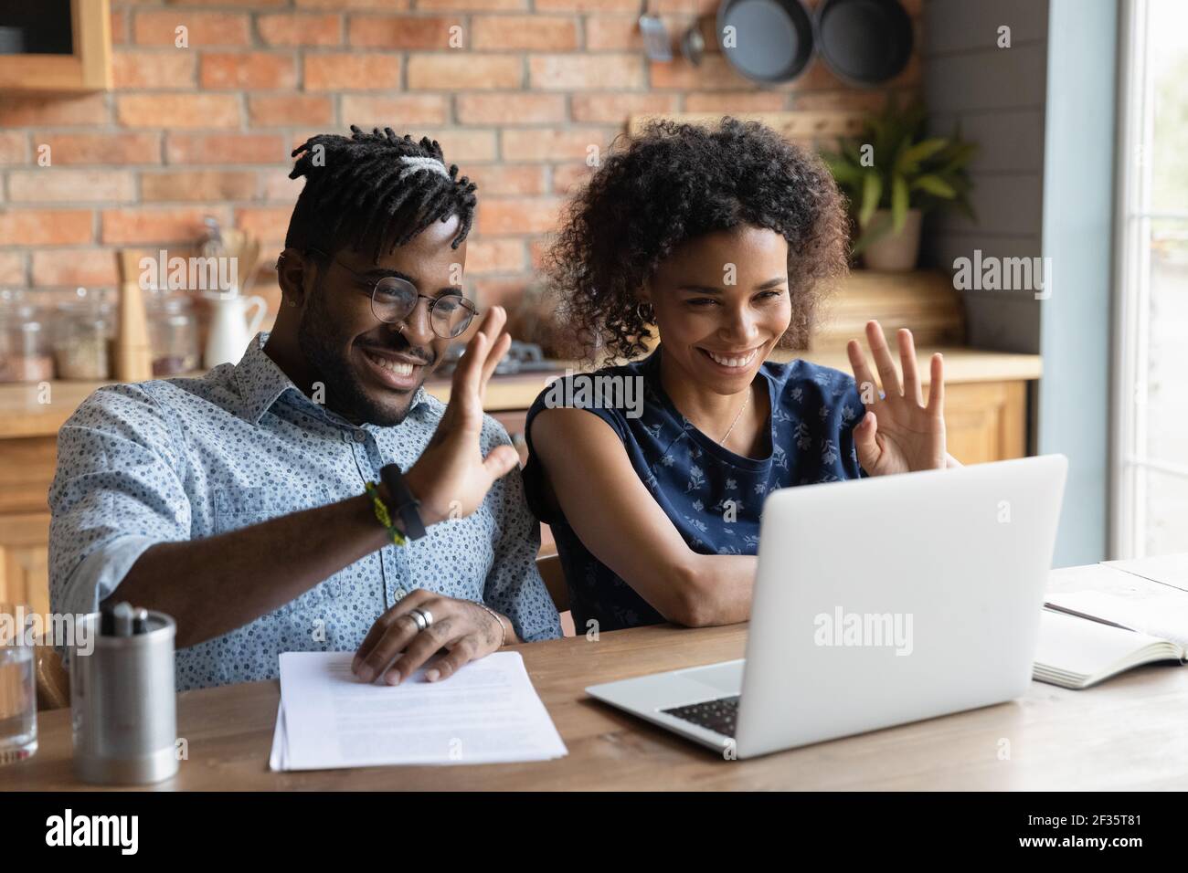Giovane afro americano coppia contatto avvocato da videocall wave mani Foto Stock