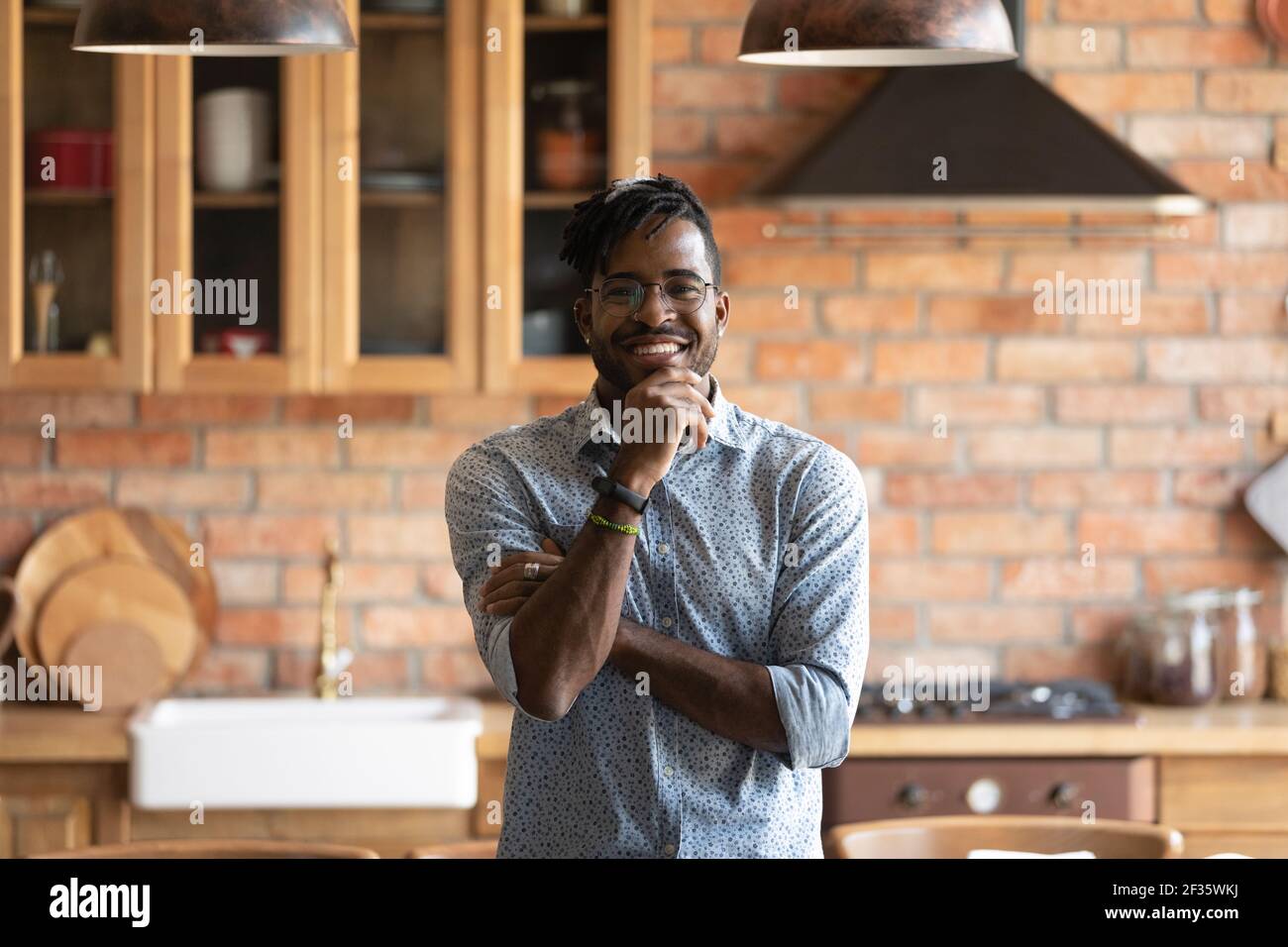 Sorridente afroamericano in posa per ritratto all'interno della cucina Foto Stock