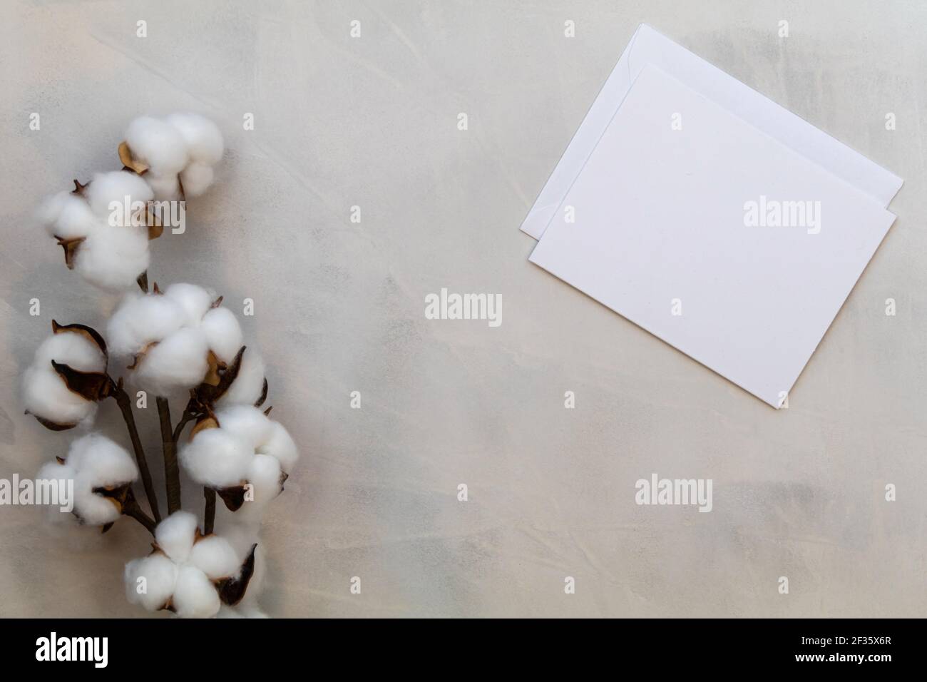 Carta bianca mockup e cotone su fondo grigio lavaggio piatto disporre lo spazio per la copia Foto Stock