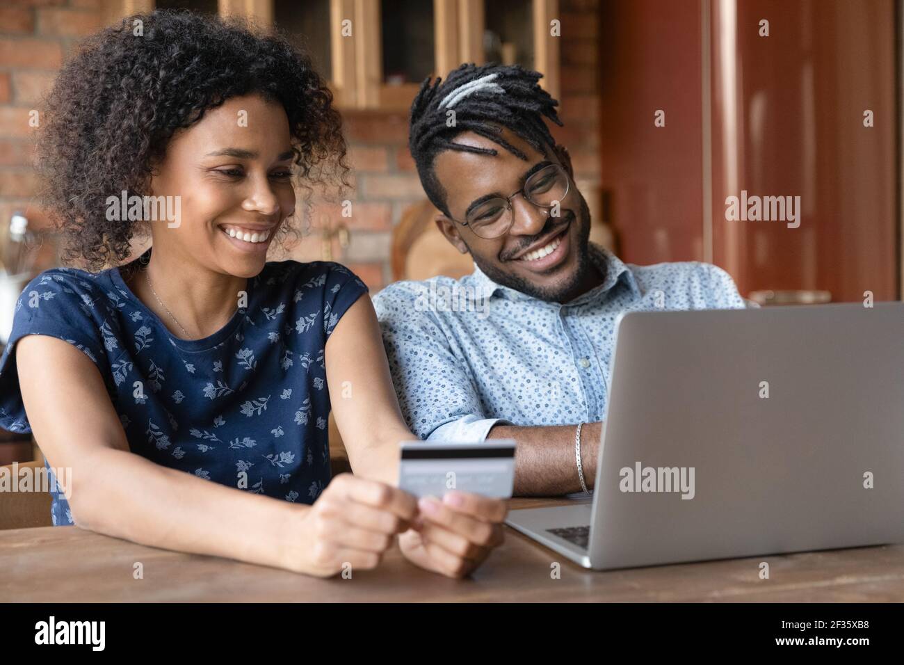 La coppia sposata afro americana fornisce il pagamento tramite l'app bancaria elettronica Foto Stock
