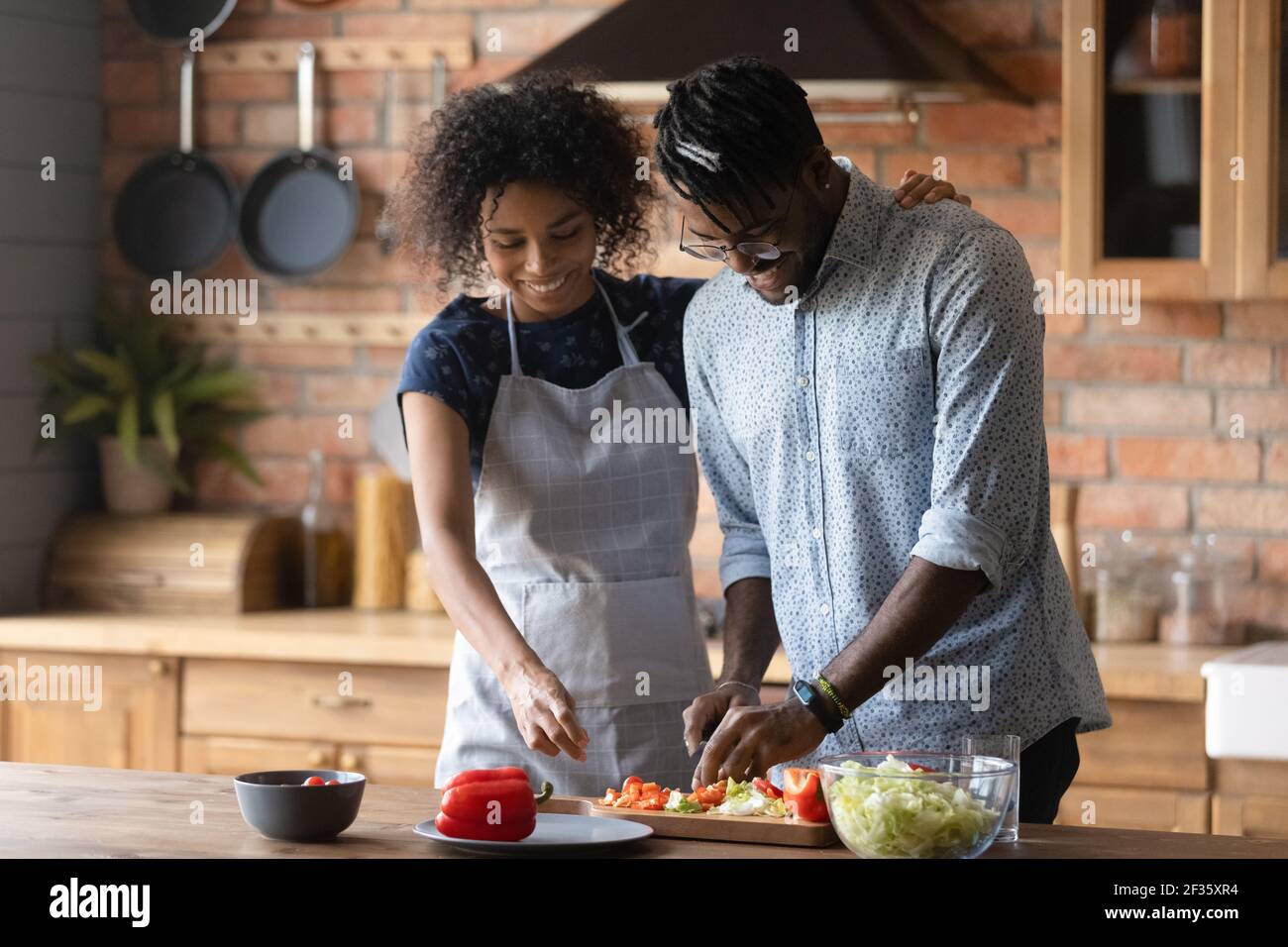 Il giovane marito africano impara a cucinare ascolta i consigli della moglie Foto Stock