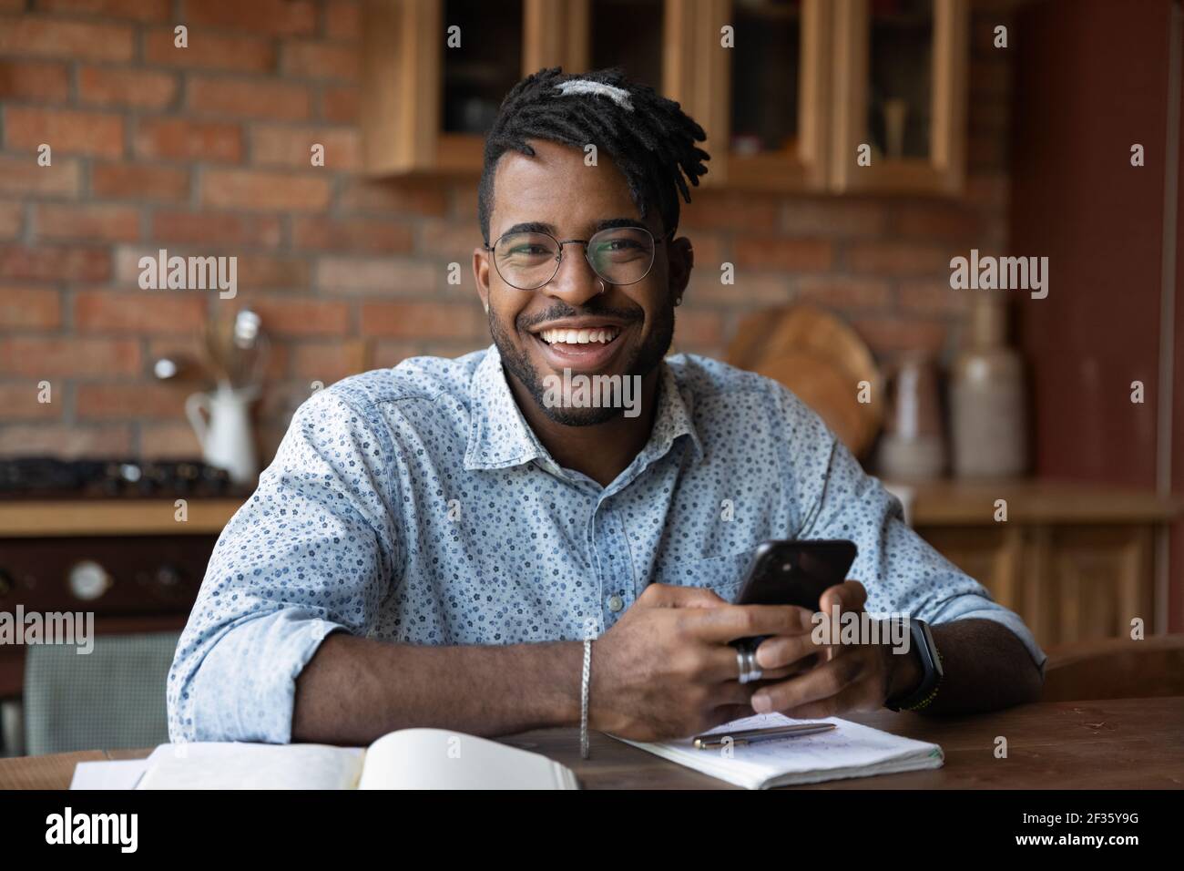 Ritratto di successo nero maschio studente di giorno moderno tenendo smartphone Foto Stock