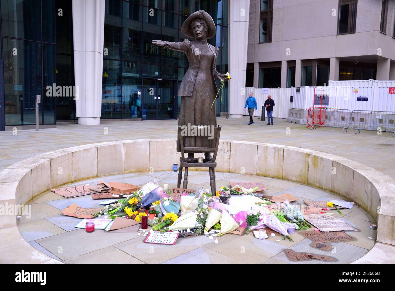 I cartelli che fanno lobby per la sicurezza delle donne e i fiori alla statua di Emmeline Pankhurst in St Peter's Square, Manchester, Inghilterra, Regno Unito, lasciarono dopo la veglia nella memoria di Sarah Everard il 13 marzo 2021. Il 12 marzo un ufficiale della polizia metropolitana di Londra è stato accusato del rapimento e dell'omicidio di Sarah Everard. Apparve alla corte dei Magistrati di Westminster il 13 marzo e fu rimesso in custodia per apparire all'Old Bailey il 16 marzo. Emmeline Pankhurst era il leader del movimento suffragette nel Regno Unito. La statua in bronzo fu scolpita da Hazel Reeves. Foto Stock