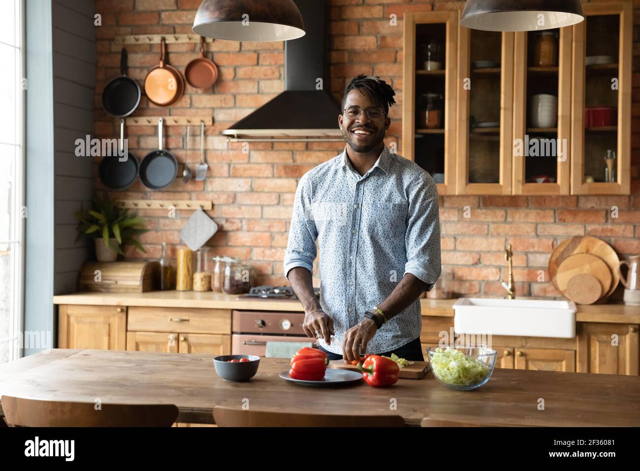 Sorridente giovane maschio nero Godetevi cucina moderna Foto Stock