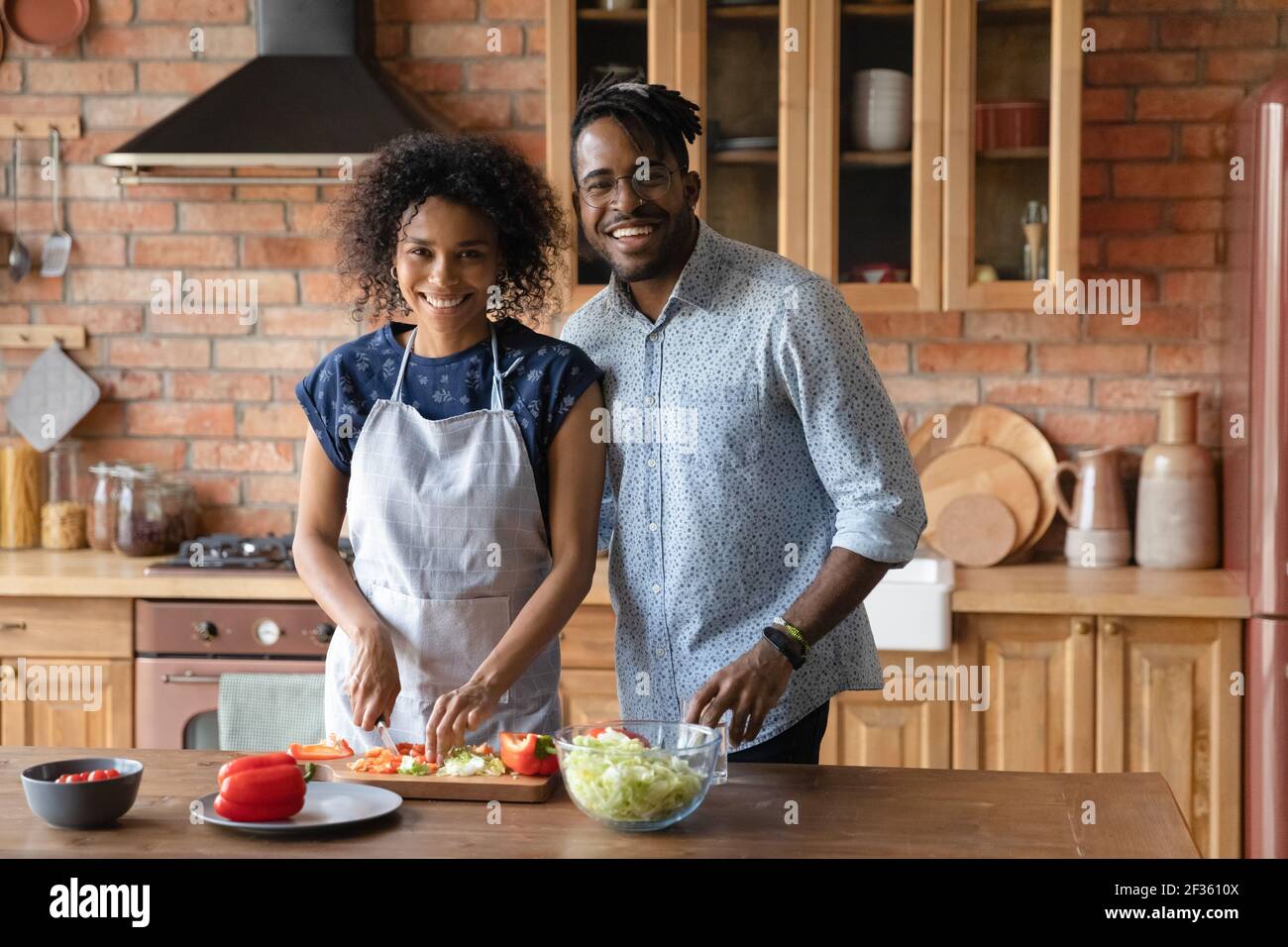 Millennial coppia nera in amore Guarda la macchina fotografica Godetevi la cucina Foto Stock