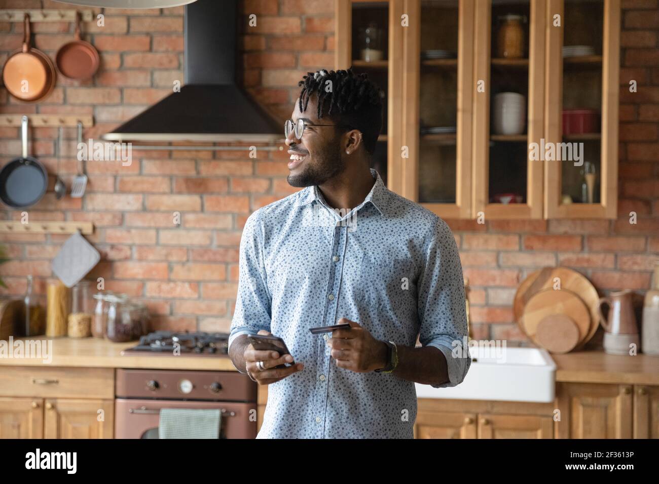 Giovane uomo nero che ordina cibo online utilizzando la carta telefonica Foto Stock