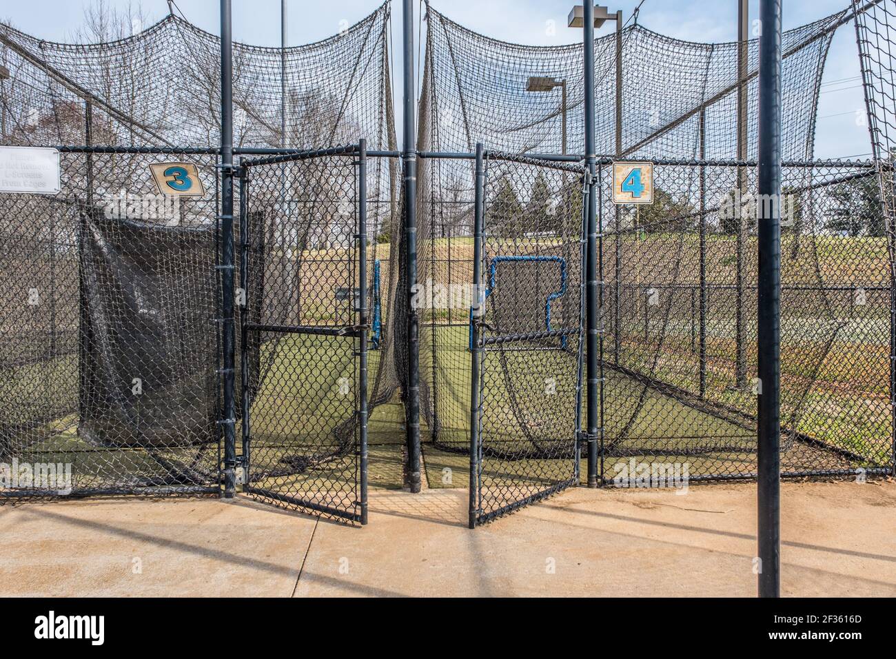 Riapertura dei campi da baseball e delle gabbie di battuta per l'uso a. il parco, mentre il coronavirus pandemico svanisce su un giornata di sole in primavera Foto Stock