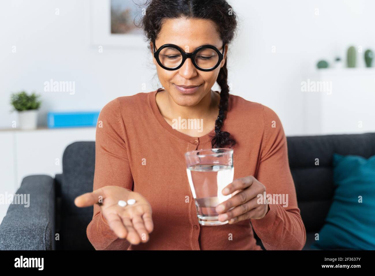 Donna afroamericana che tiene pillole di medicina in mano Foto Stock