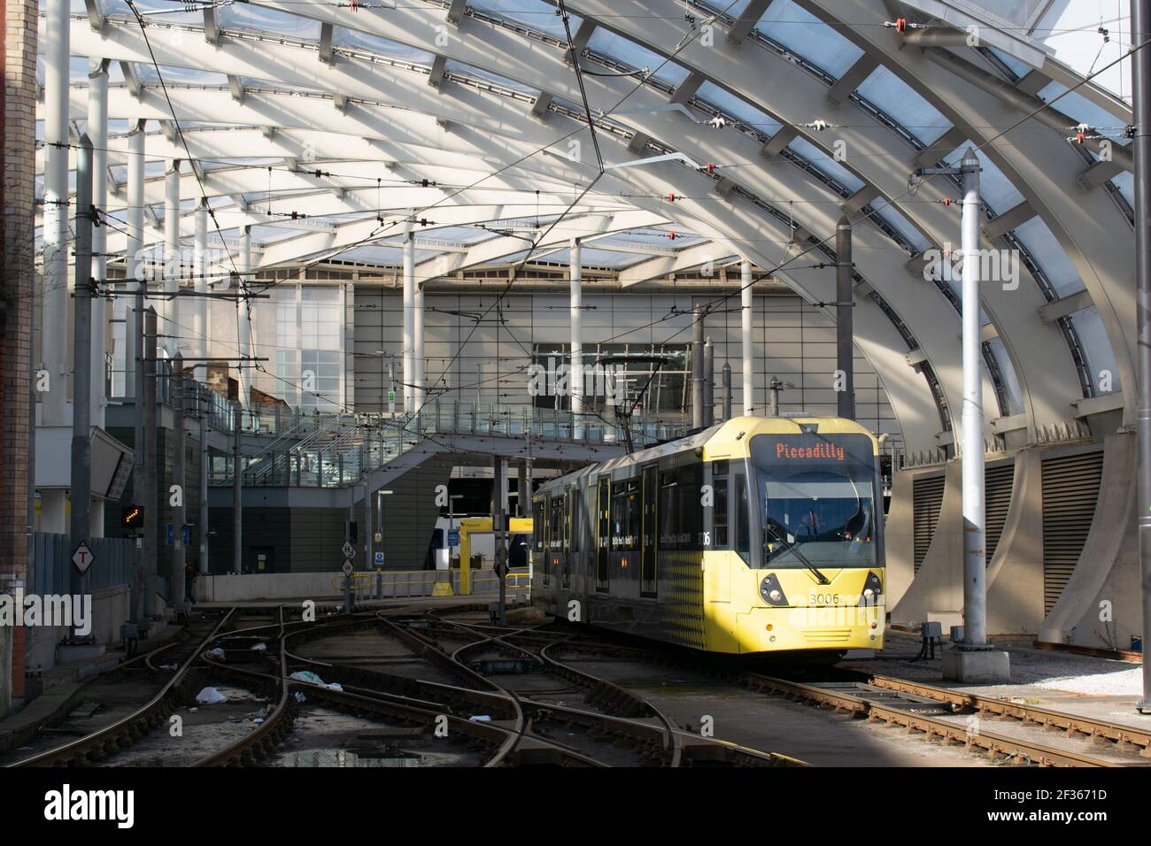 Stazione Victoria con tram giallo Metrolink sulla rotta per Piccadilly uscita dalla stazione Foto Stock