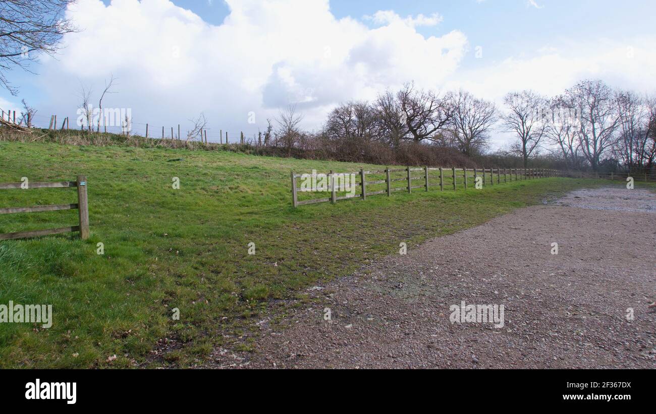Corsia di paese inglese che corre lungo un campo con recinzione e. spazio di copia Foto Stock