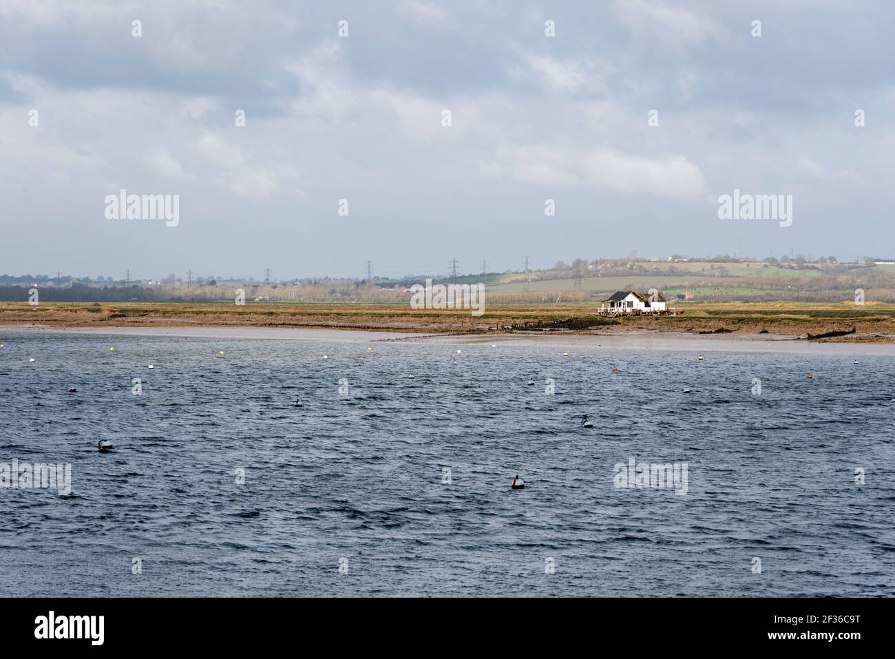 Lone, singola cabina isolata in decadimento sulla riva del fiume Crouch a North Fambridge, Rochford, Essex, Regno Unito. Verricello, acqua fredda. Paesaggio stellato Foto Stock