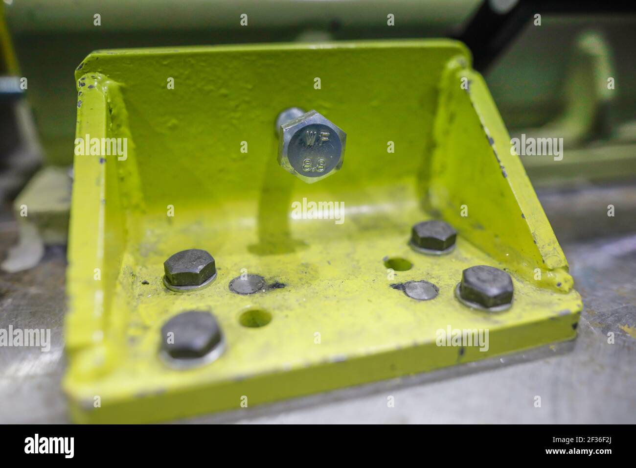 Immagine della profondità di campo poco profonda (messa a fuoco selettiva) con dettagli di dadi e bulloni metallici industriali in una fabbrica pesante. Foto Stock