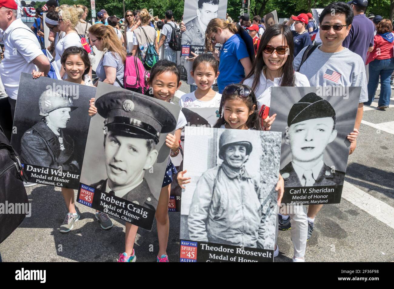 Washington DC, National Memorial Day Parade, area di staging volontari giovani Asian ragazza scouts Spirito di 45, adolescenti tenendo foto in onore della seconda guerra mondiale v Foto Stock