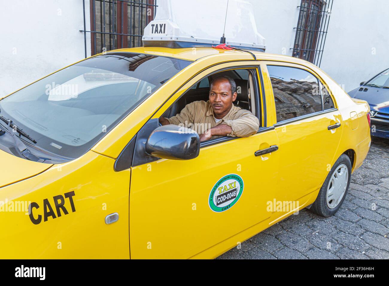 Santo Domingo Repubblica Dominicana, Ciudad Colonia zona Colonial, Calle Isabel la Catolica nero ispanico taxi uomo, lavoro di lavoro giallo, Foto Stock