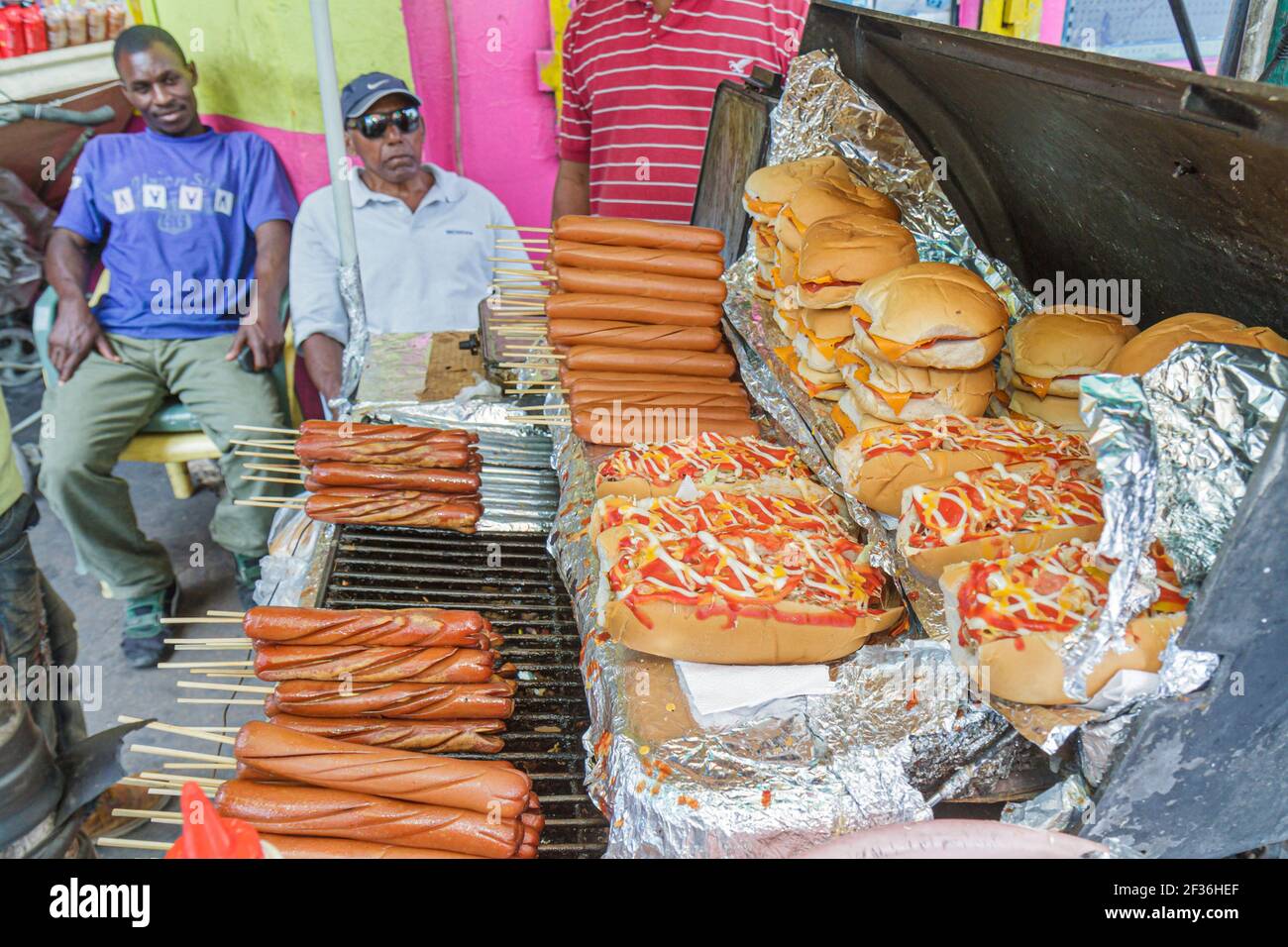 Santo Domingo Repubblica Dominicana, Calle Rovelo, venditori alimentari stalla hot dog cart griglia hamburger condimenti, uomini ispanici neri, Foto Stock