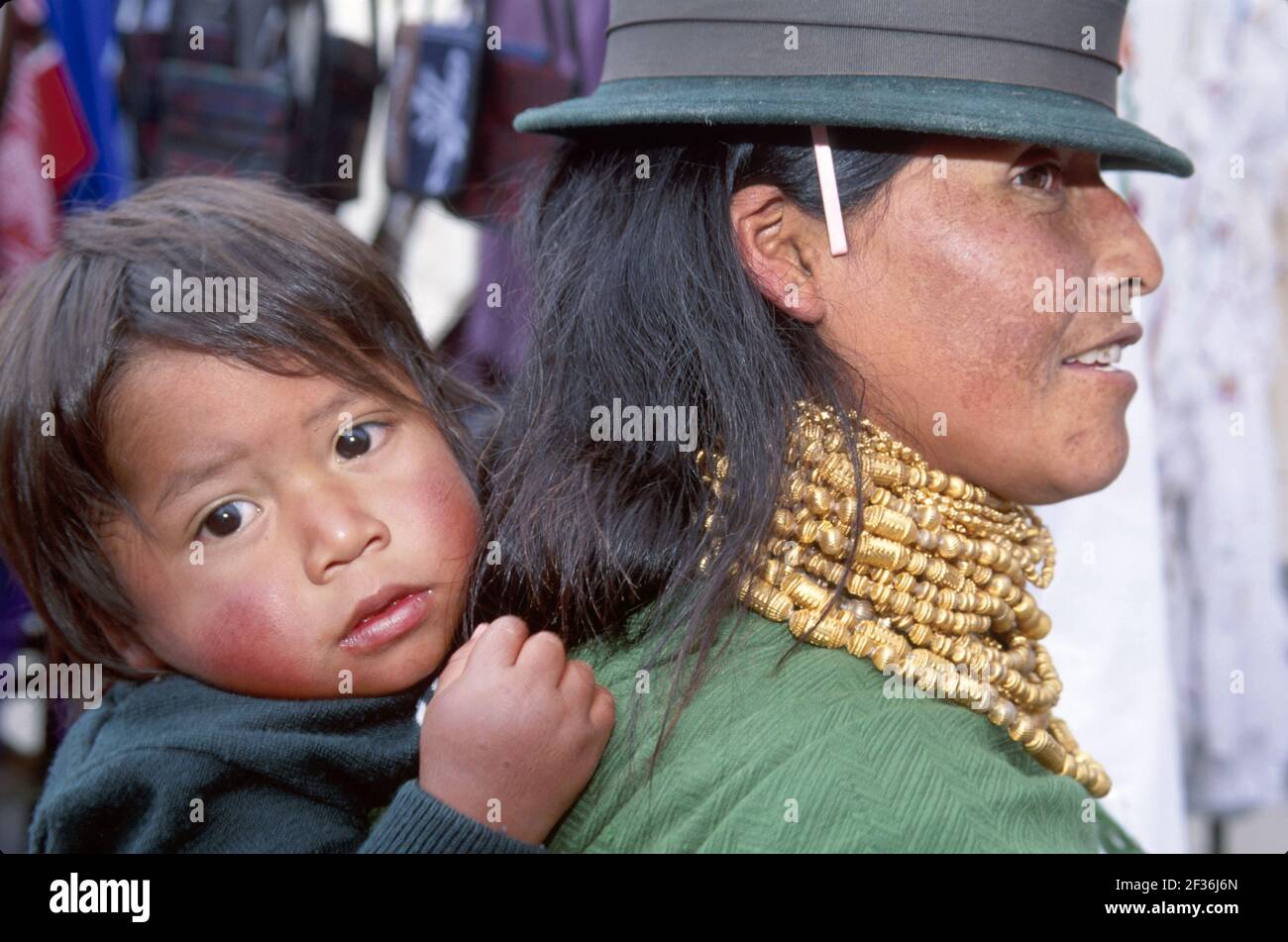 Ecuador Equadoriano Sudamerica America americana mercato di Otavalo, madre donna femmina bambino che indossa perle indigene, Foto Stock