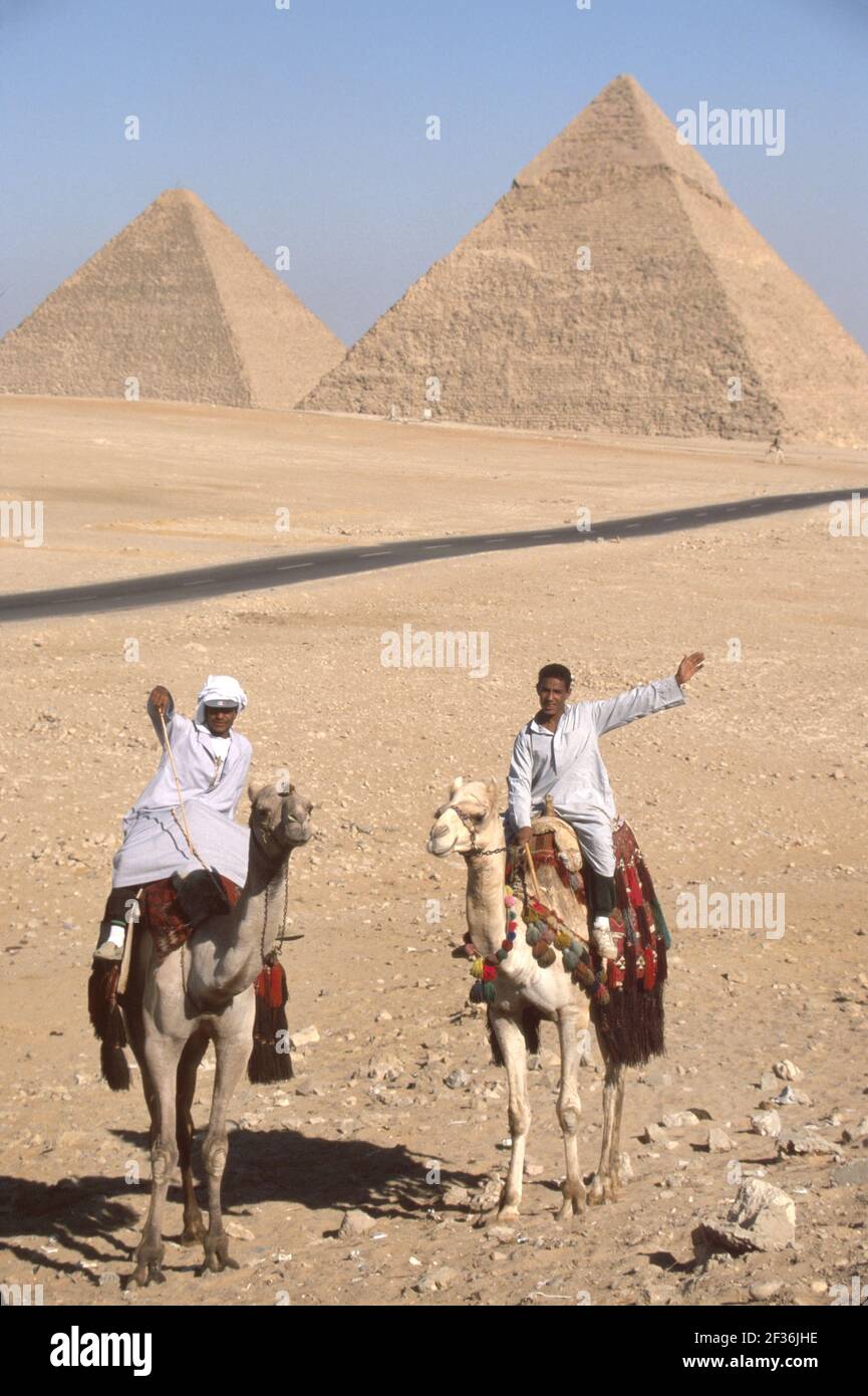 Cairo Egitto Giza Egiziano Distretto Grande Piramide di Kheops, costruito 2600 a.C. a.C. sette meraviglie del mondo, uomini musulmani cammello rider che offrono giostre, Foto Stock