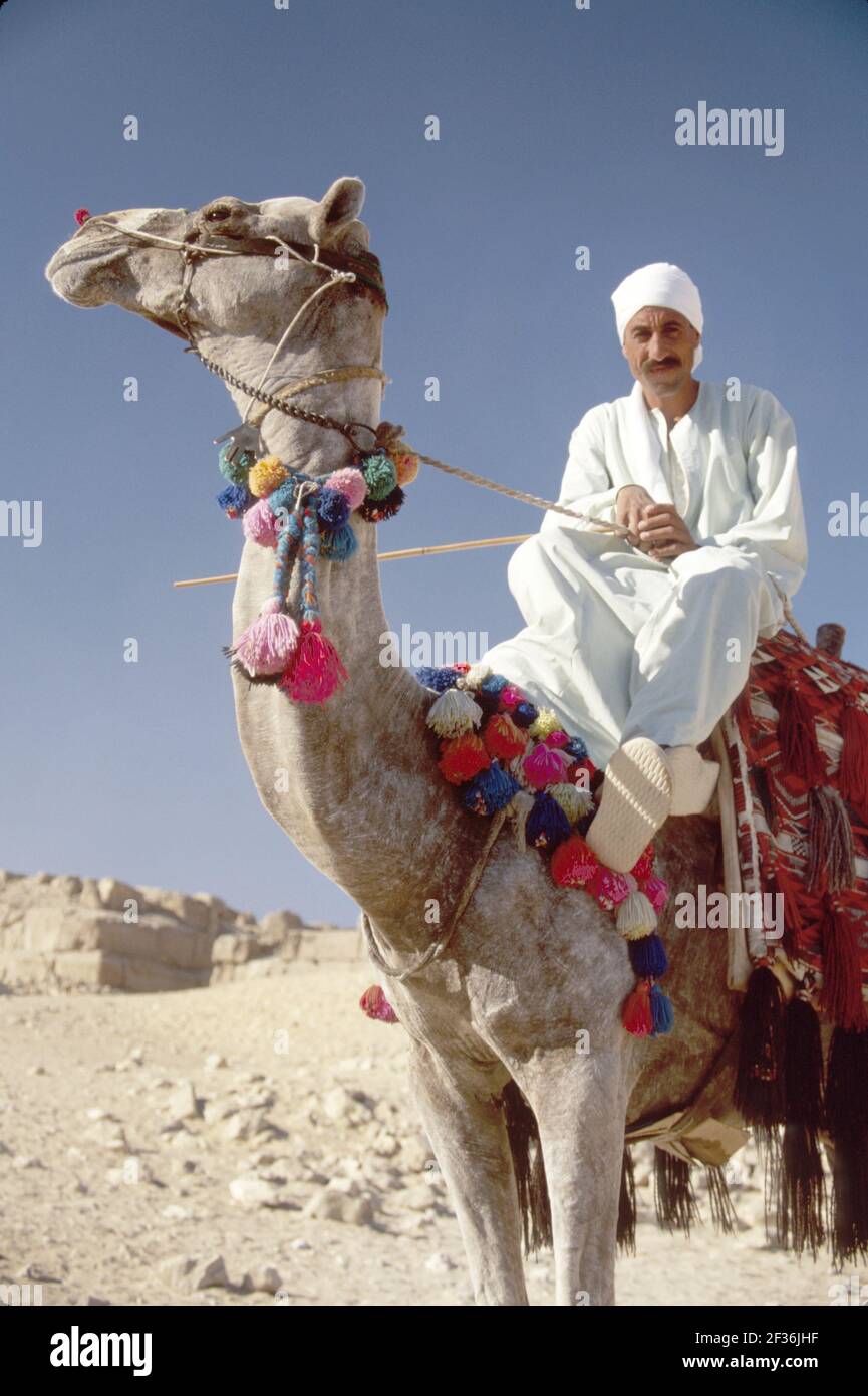 Cairo Egitto Giza Egiziano Distretto Grande Piramide di Kheops, costruito 2600 a.C. a.C. sette meraviglie del mondo, uomo musulmano cammello rider che offre giostre, Foto Stock