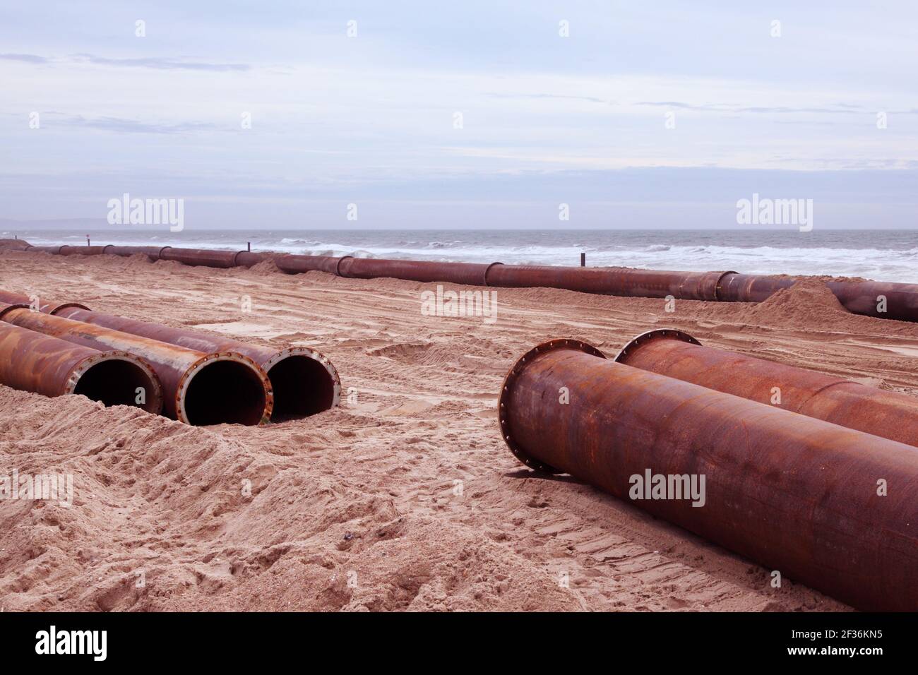 Grandi tubi metallici o pipeline sulla spiaggia di Boscombe, Bournemouth. Usato per pompare più sabbia sulle spiagge da offshore. Foto Stock