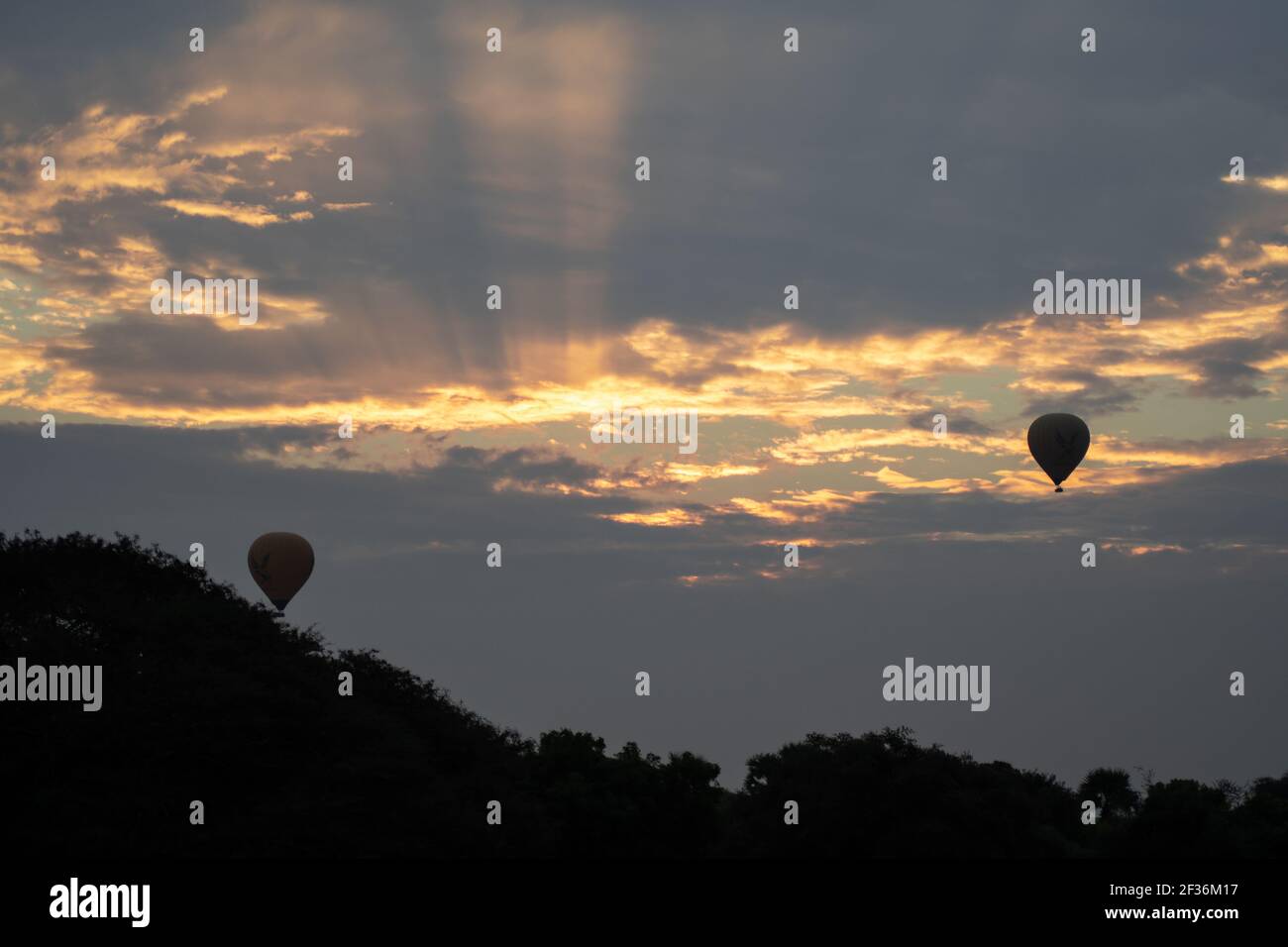 BAGAN, NYAUNG-U, MYANMAR - 2 GENNAIO 2020: Due mongolfiere nel cielo durante l'alba della mattina presto in una giornata nuvolosa Foto Stock