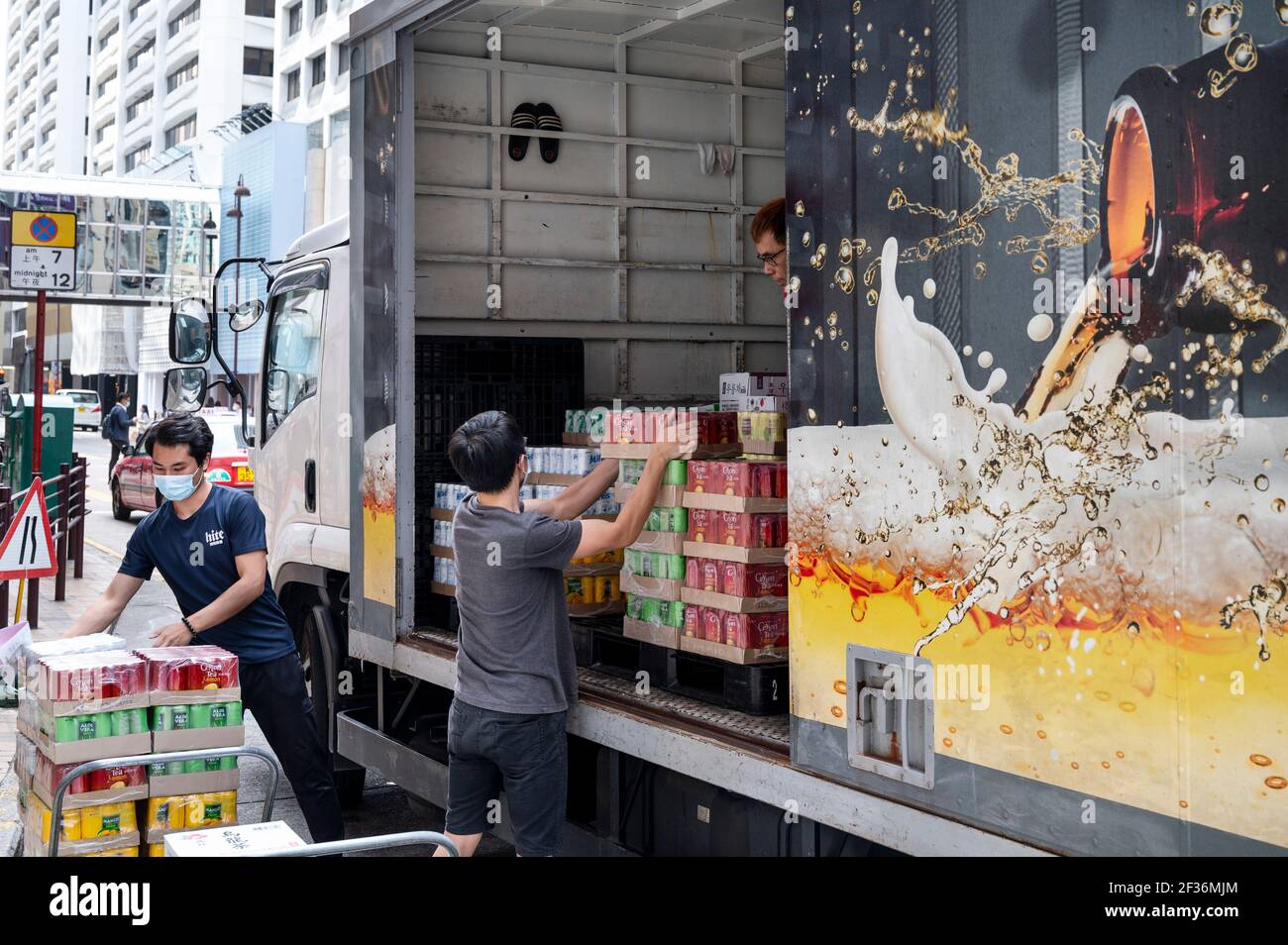 Hong Kong, Cina. 12 marzo 2021. Consegna camion lavoratori scaricare bevande di marca come bevande analcoliche e alcolici, a Hong Kong Credit: Budrul Chukrut/SOPA Images/ZUMA Wire/Alamy Live News Foto Stock