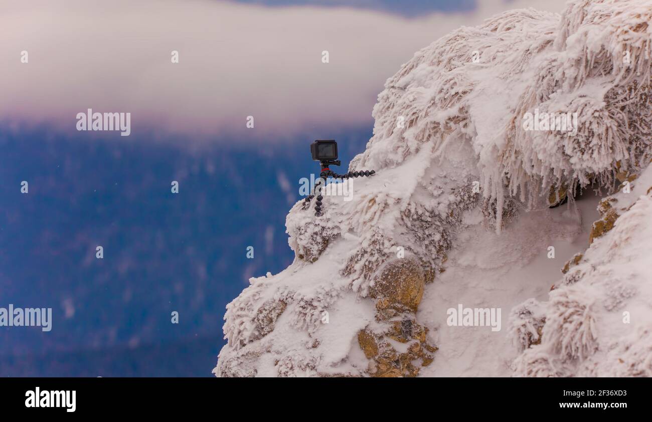 piccola videocamera d'azione su un treppiede. registrazione di un timelapse in montagna Foto Stock