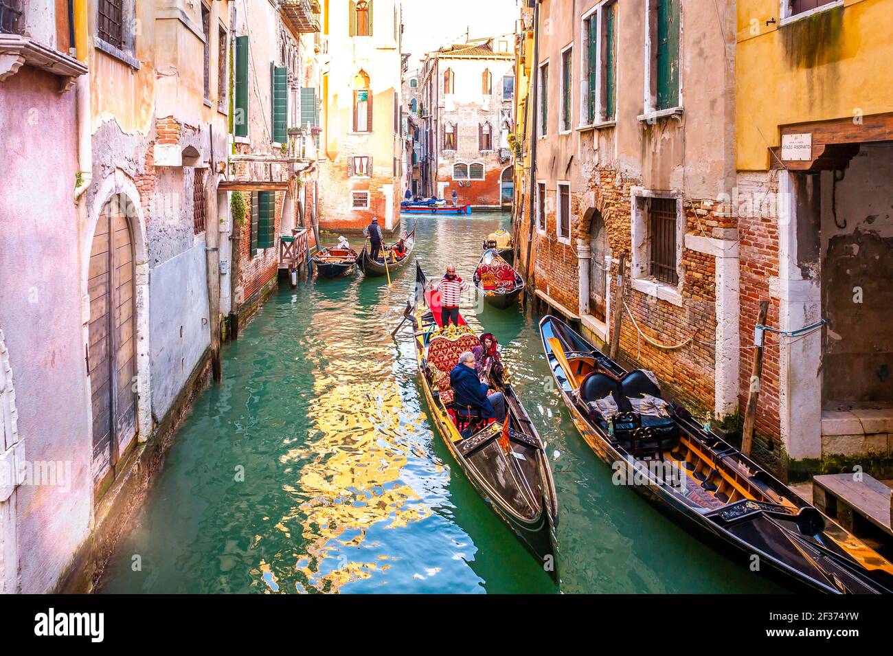 Gondole con turisti navigano su un canale a Venezia, Veneto, Italia Foto Stock