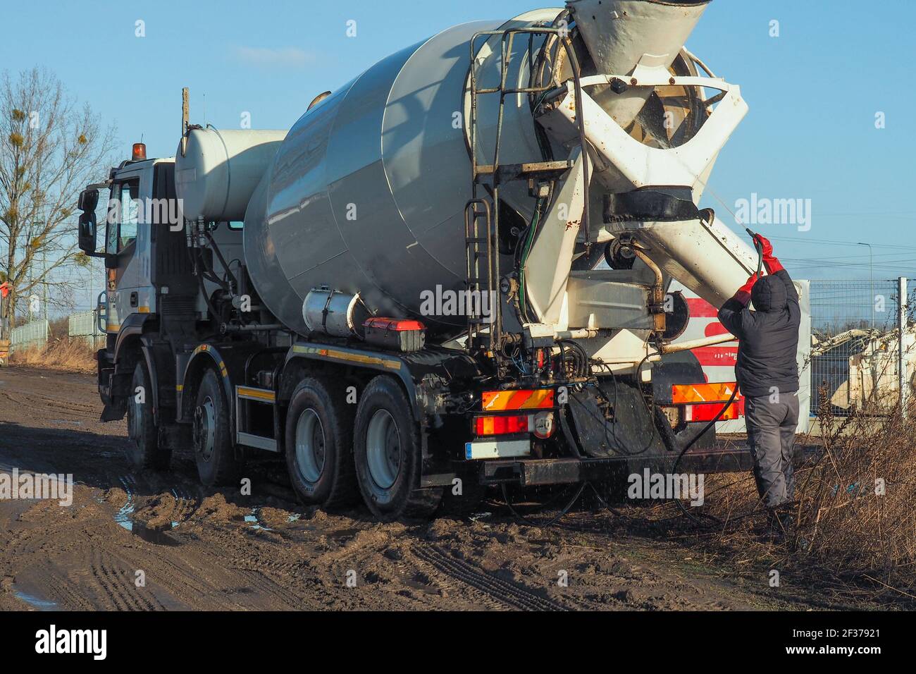 il conducente lava il carrello con una betoniera dopo lavoro Foto Stock