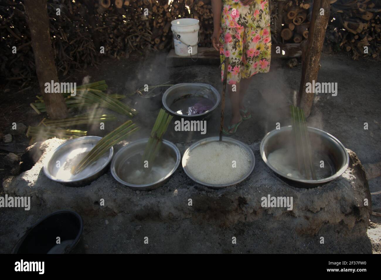 Una donna che bolle la palma sap per fare lo zucchero di palma, una fonte alternativa di reddito per gli abitanti di un villaggio che vivono a Rote Island, Indonesia. Foto Stock