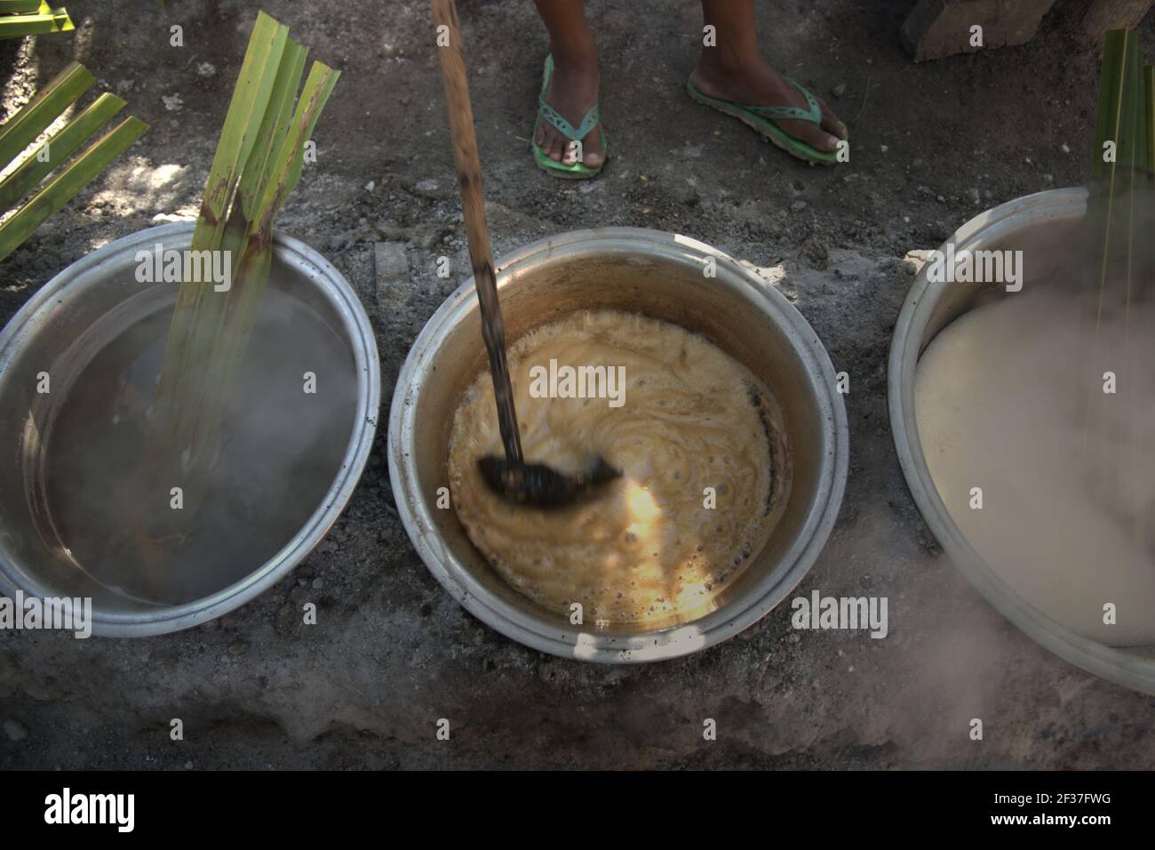 Ciotole contenenti sap di palma bollito per la produzione di zucchero di palma a Rote Island, Indonesia. Foto Stock