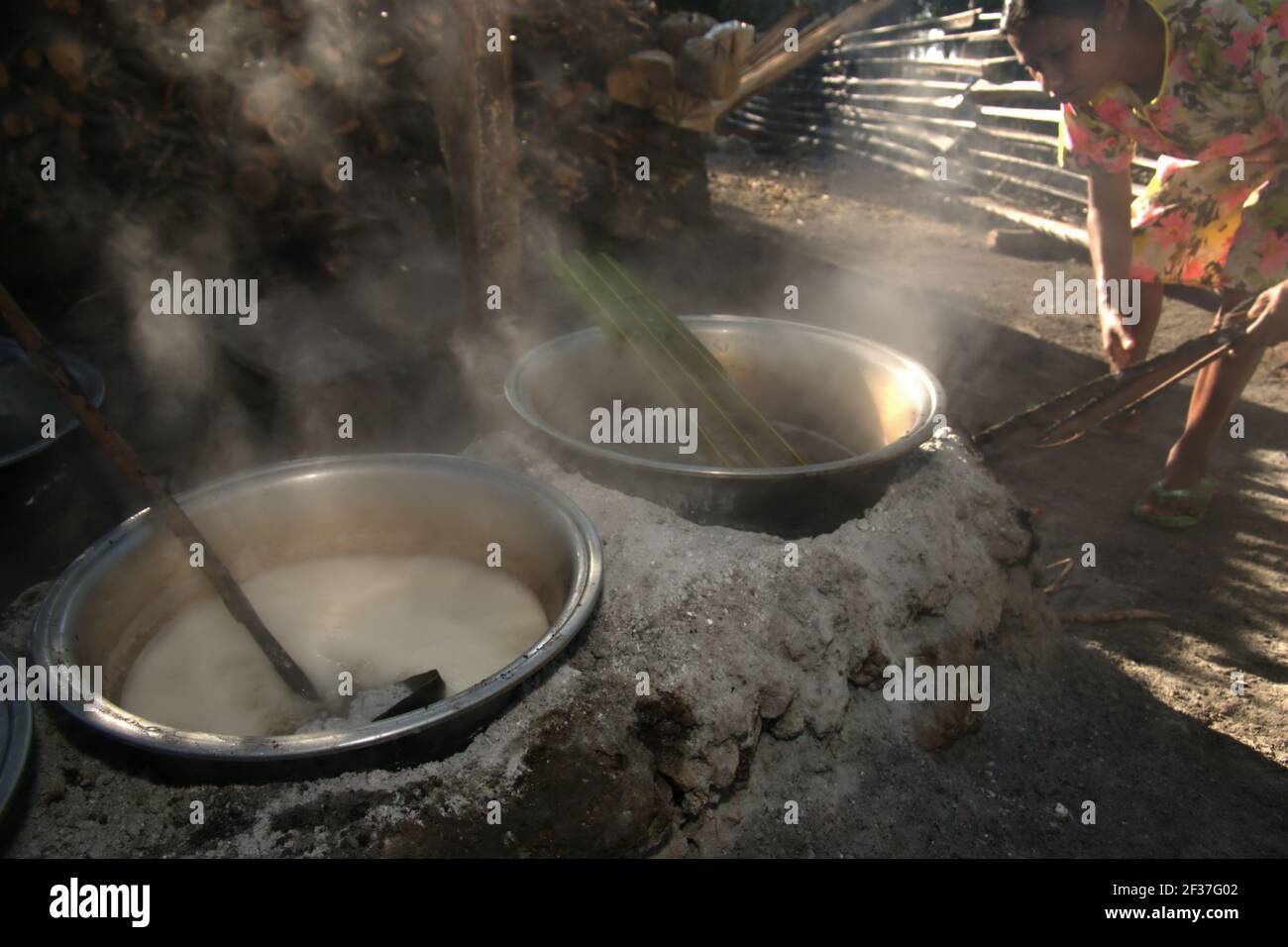 Una donna che bollente la palma sap per fare zucchero di palma nel villaggio di Oehandi, Isola di Rote, Indonesia. Foto Stock