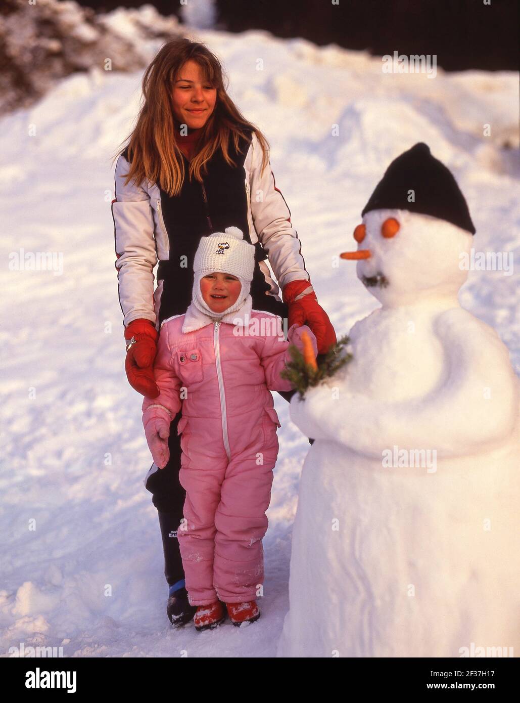 Ragazze con pupazzo di neve, St.Anton (Sankt Anton am Arlberg), Tirolo, Austria Foto Stock