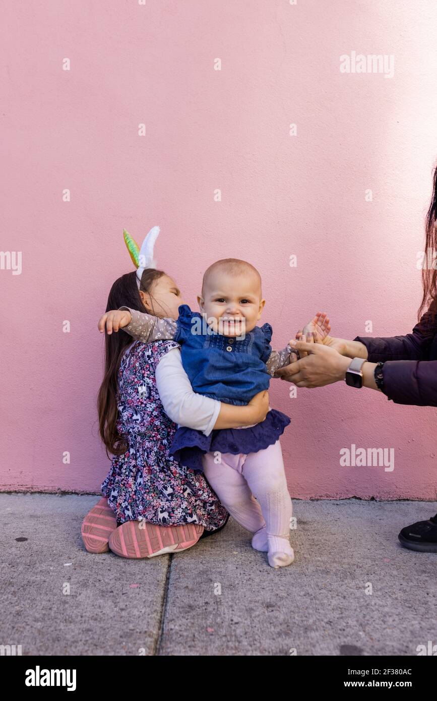 Adorabile bambina che indossa archetto unicorno abbracciando la sua sorella  del bambino Foto stock - Alamy