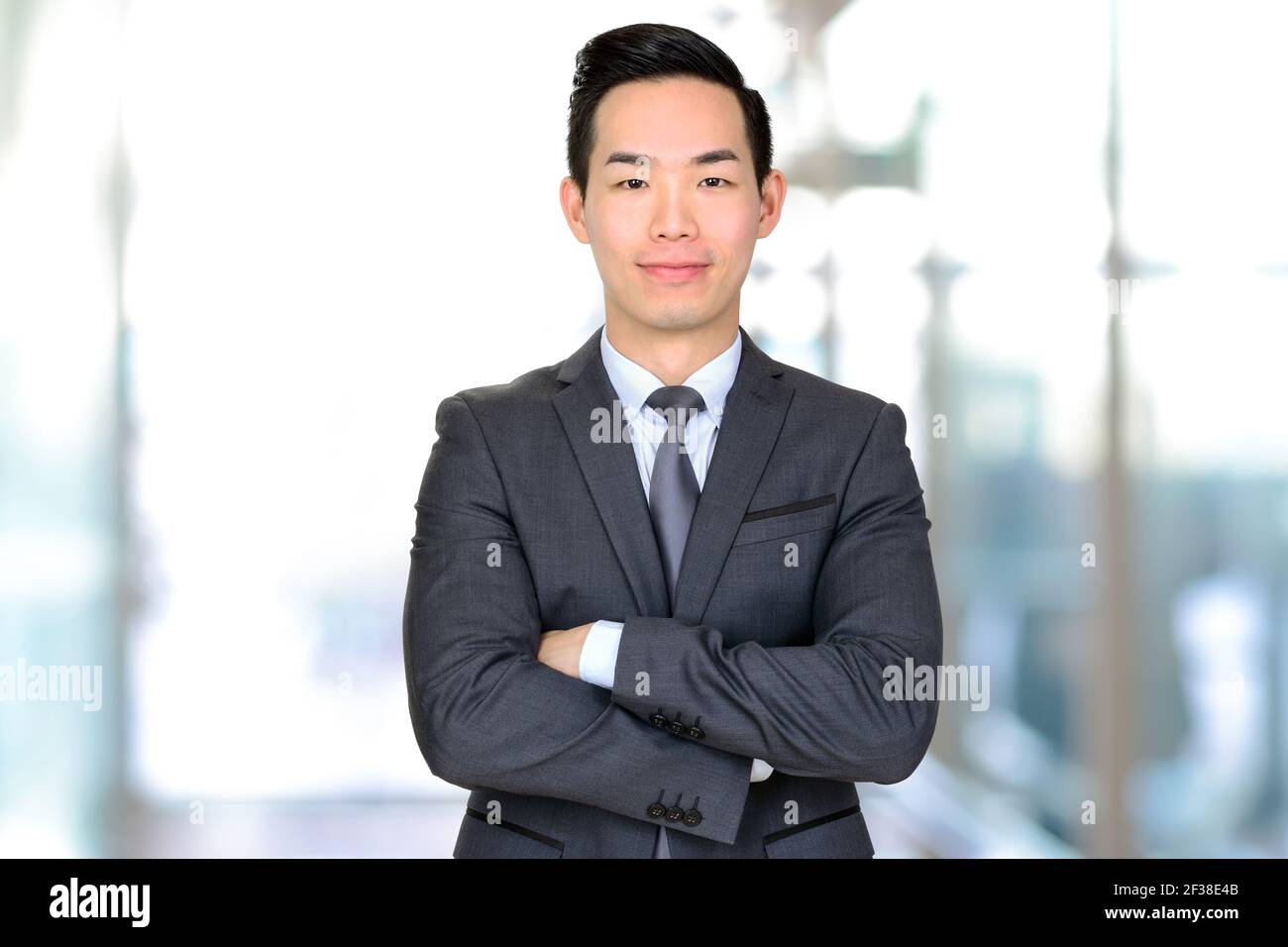 Giovane uomo d'affari asiatico che attraversa le braccia Foto Stock