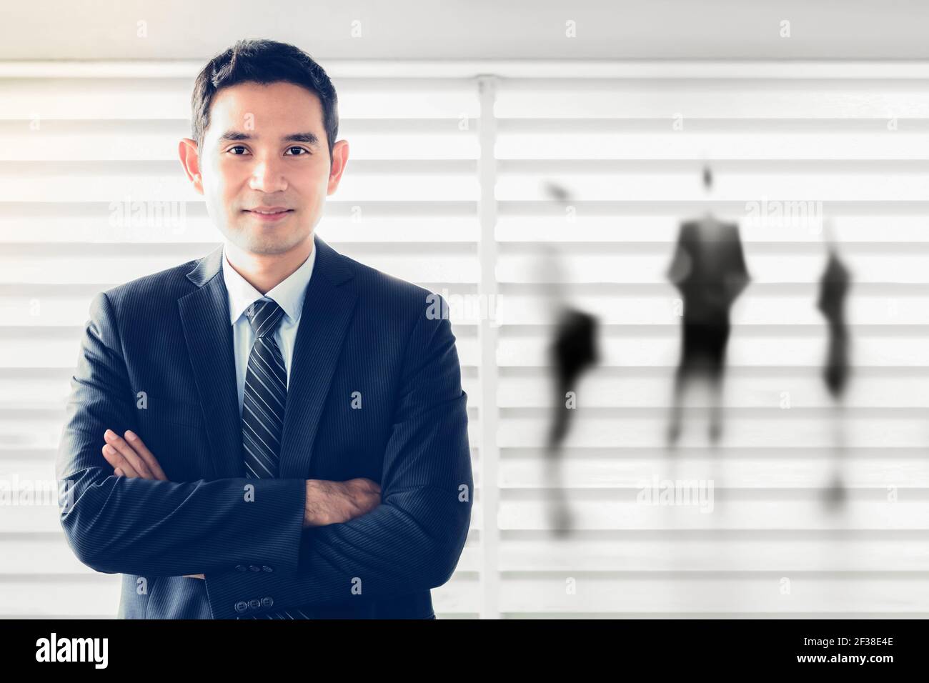 Sorridente uomo d'affari asiatico che attraversa le braccia - leader e successo concetto di uomo d'affari Foto Stock