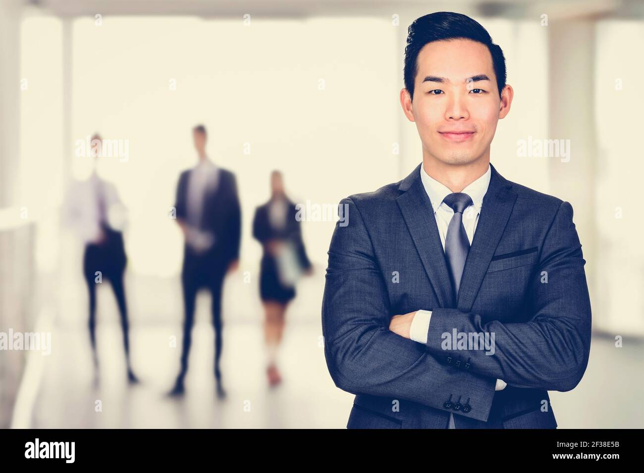 Sorridente uomo d'affari asiatico che attraversa le braccia - leader e successo concetto di uomo d'affari Foto Stock