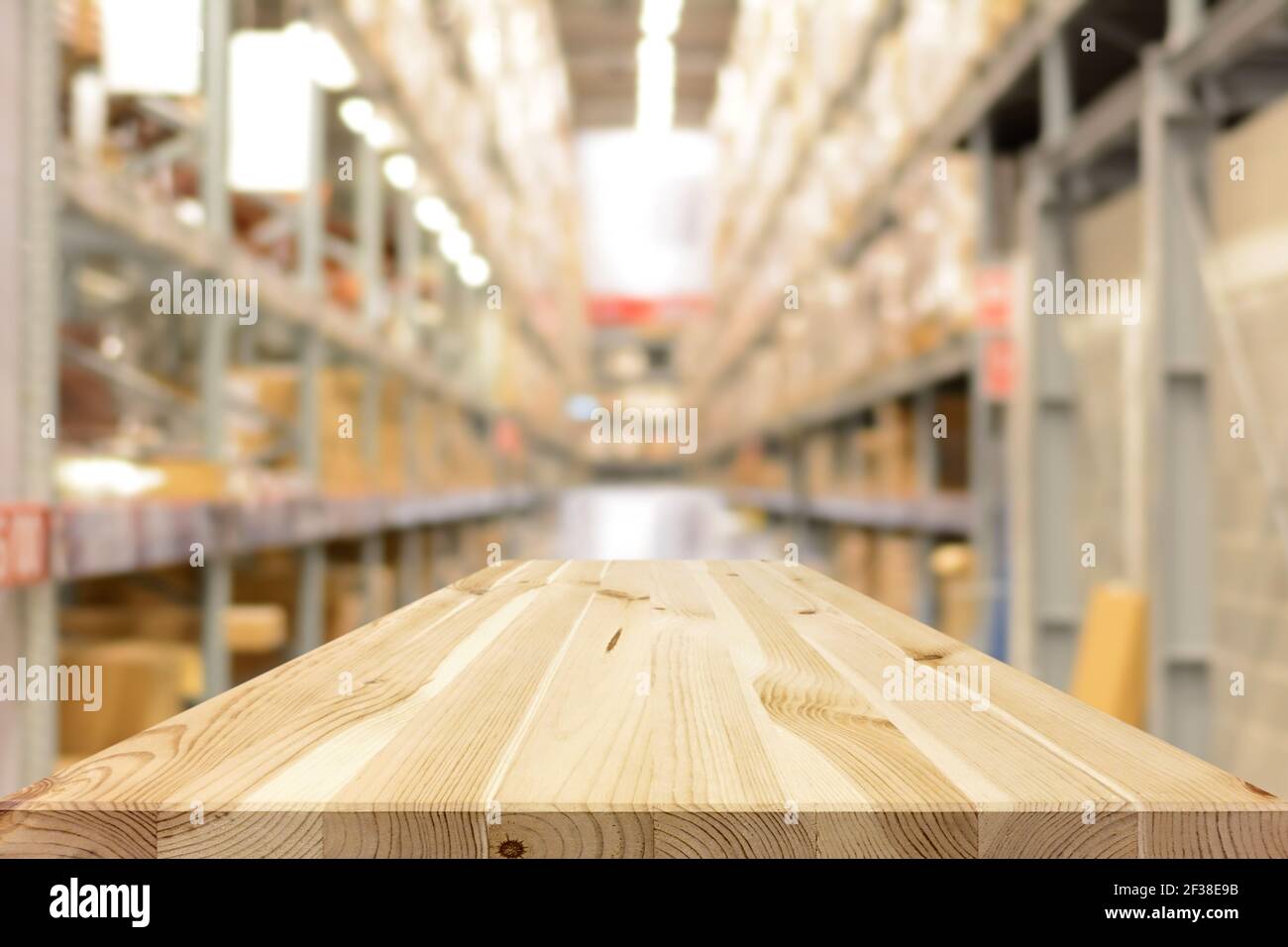 Svuotare il piano del tavolo (o il ripiano) in legno sullo sfondo del magazzino sfocato Foto Stock