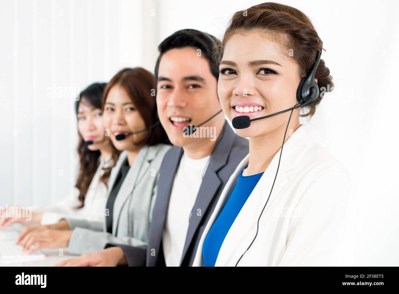 Call center sorridente (o telemarketer) team - concetto di operatore del servizio clienti Foto Stock