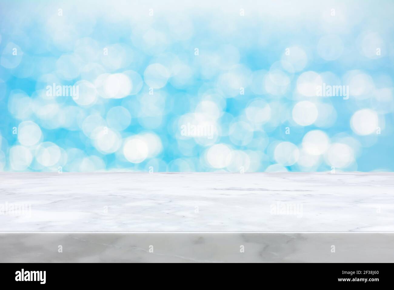 Piano di contrasto in marmo bianco su sfondo astratto bokeh azzurro - può essere utilizzato per la visualizzazione o il montaggio dei prodotti Foto Stock