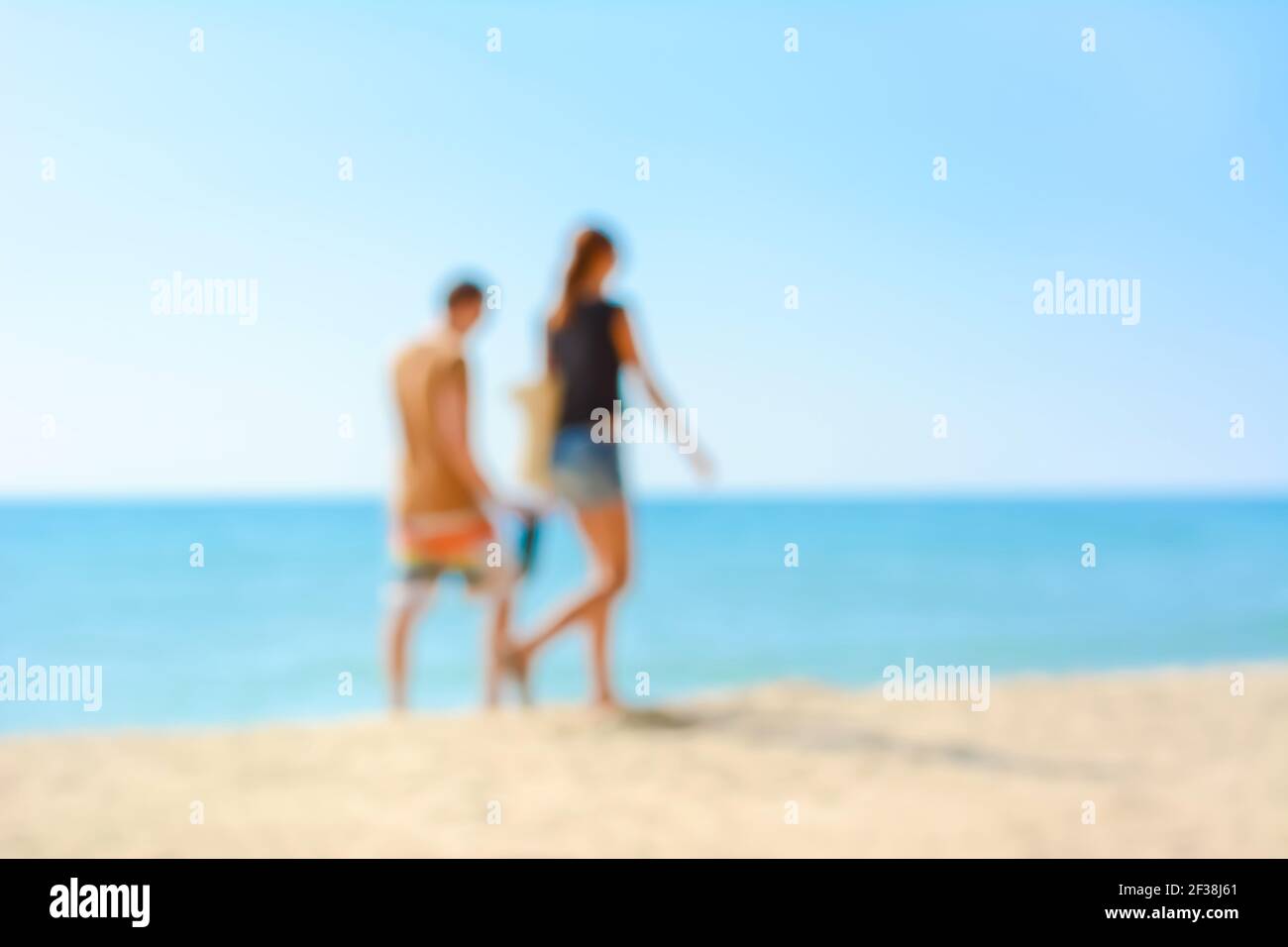 Immagine sfocata della coppia che cammina sulla spiaggia, concetto di sfondo delle vacanze estive Foto Stock