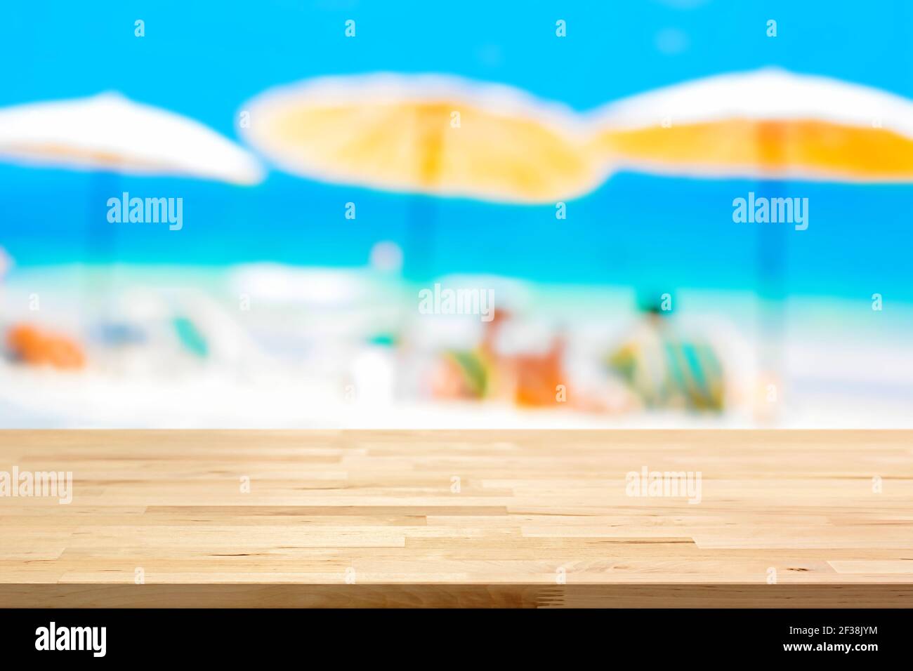 Tavolo in legno sullo sfondo della spiaggia sfocato, concetto di sfondo delle vacanze estive - può essere utilizzato per il montaggio o la visualizzazione dei vostri prodotti Foto Stock