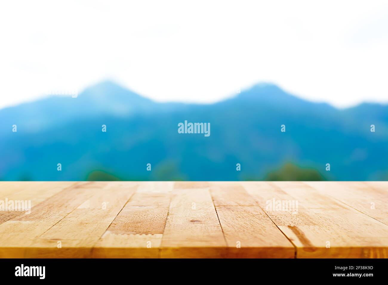 Tavolo in legno su sfondo di montagna sfocata - può essere utilizzato per la visualizzazione o il montaggio dei prodotti Foto Stock
