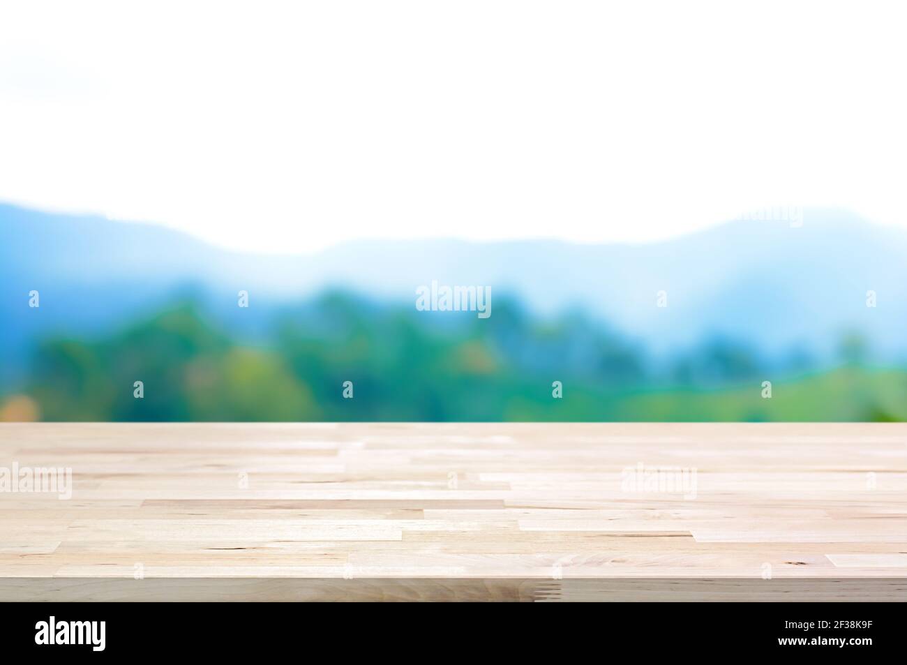 Tavolo in legno su sfondo di montagna sfocata - può essere utilizzato per la visualizzazione o il montaggio dei prodotti Foto Stock